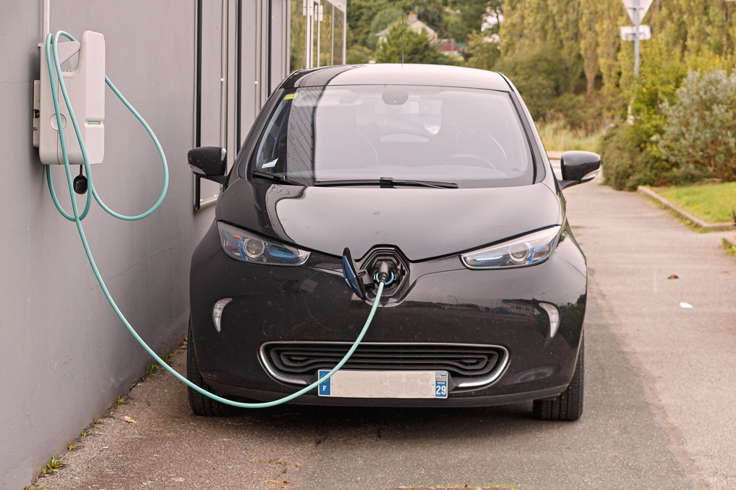 Une voiture électrique est en train de se recharger via une borne de recharge